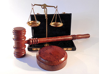 A judicial gavel and justice scales in front of an open case